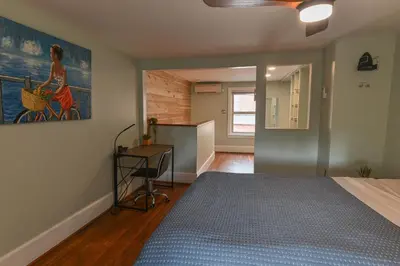 a bedroom with a bed and a painting on the wall at BurgBnB Downtown in Harrisburg