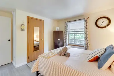 a bedroom with a bed with a clock on the wall at Community Pools and Hot Tub Albrightsville Cottage! in Albrightsville
