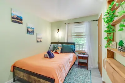 a bedroom with a bed with orange sheets and blue pillows at Community Pools and Hot Tub Albrightsville Cottage! in Albrightsville