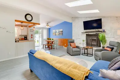 a living room with a blue couch and a fireplace at Community Pools and Hot Tub Albrightsville Cottage! in Albrightsville