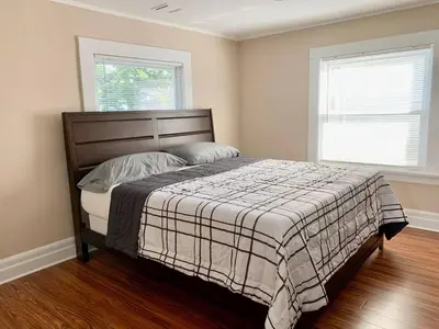 a bedroom with a bed and two windows at Newly Renovated 2 BR downtown Apt, family getaway. in Montclair
