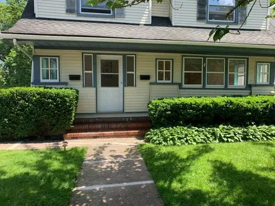 a house with a white door and some bushes at Newly Renovated 2 BR downtown Apt, family getaway. in Montclair