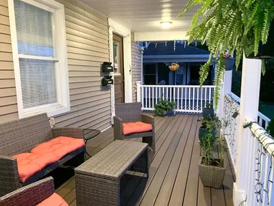 a porch with wicker chairs and benches on a house at Semi Private cozy studio near downtown. in Montclair