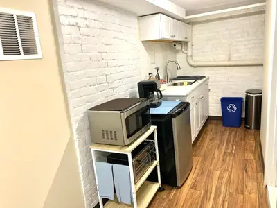 a small kitchen with a microwave and a stove at Semi Private cozy studio near downtown. in Montclair
