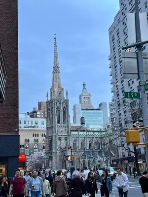 a group of people walking on a city street with a cathedral at Double Room in New York