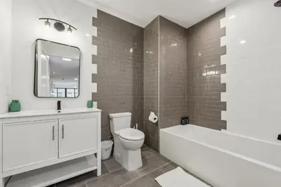 a white bathroom with a tub and a toilet and a sink at Beautiful New Apartment I 1 Bedroom 1 Bathroom in Wilmington