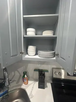 a kitchen counter with a sink and plates in a cabinet at Cozy 2-3 Bedroom Apartment in Center City! in Philadelphia