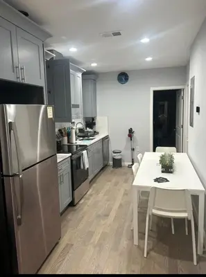 a kitchen with a white table and a refrigerator at Cozy 2-3 Bedroom Apartment in Center City! in Philadelphia