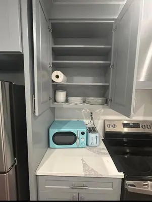 a kitchen with a counter with a microwave and a stove at Cozy 2-3 Bedroom Apartment in Center City! in Philadelphia