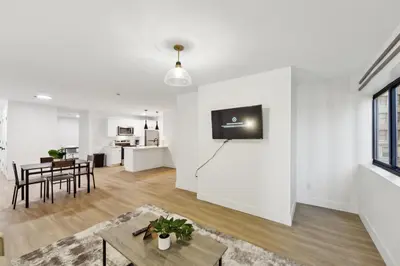 a living room with white walls and a tv on a wall at Market View Residence 503 I 1 Bedroom 15 Bathroo in Wilmington