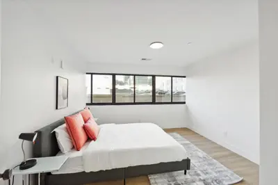 a white bedroom with a bed with orange pillows at Market View Residence 504 I 2 Bedroom 2 Bathroom in Wilmington