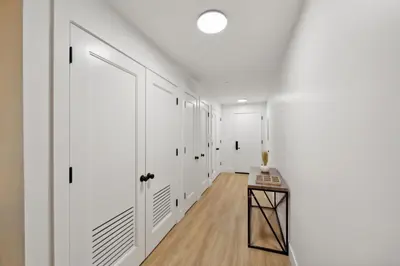 a hallway with white doors and a wooden table at Market View Residence 504 I 2 Bedroom 2 Bathroom in Wilmington