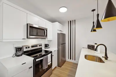 a white kitchen with a sink and a microwave at Market View Residence in Wilmington