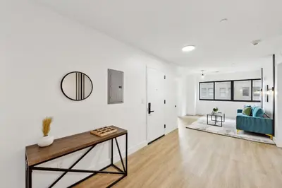 a white living room with a blue couch and a table at Market View Residence 601 I 1 Bedroom 1 Bathroom in Wilmington