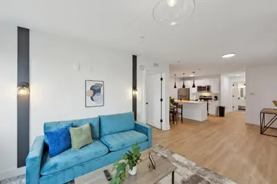 a living room with a blue couch and a kitchen at Market View Residence 601 I 1 Bedroom 1 Bathroom in Wilmington