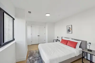 a white bedroom with a large bed with red pillows at Stunning 1bd1bth I New Construction in Wilmington