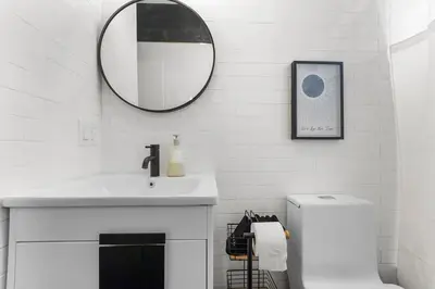 a bathroom with a sink and a mirror on the wall at 4BR Duplex, Prime Location in Newark