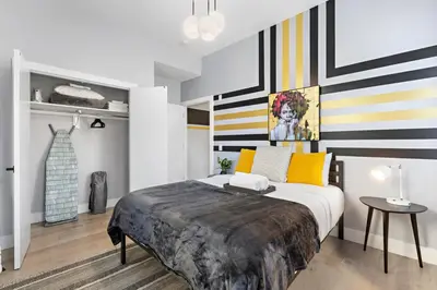 a bedroom with a large bed with striped walls at 4BR Duplex, Prime Location in Newark