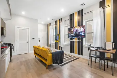 a living room with a yellow couch and a table at 4 Suites Near Downtown Newark in Newark