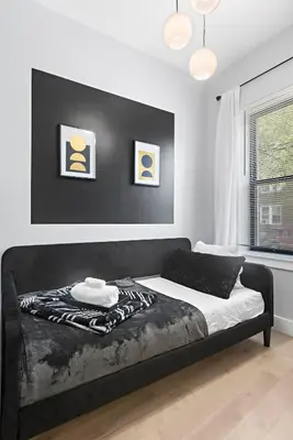 a bedroom with a black and white bed in a room at 4 Suites Near Downtown Newark in Newark