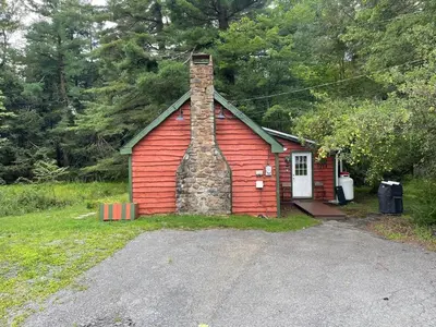 a small red house with a chimney on the front at The Cozy Cabin in Blakeslee