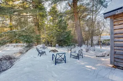 a group of chairs in the snow next to a cabin at The Cozy Cabin in Blakeslee