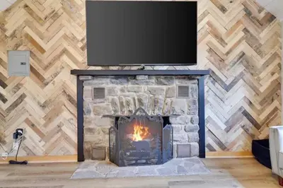 a fireplace with a television on top of it at The Cozy Cabin in Blakeslee