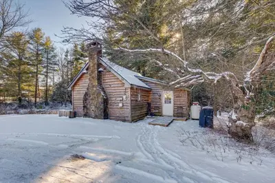 a log cabin with snow on the ground at The Cozy Cabin in Blakeslee