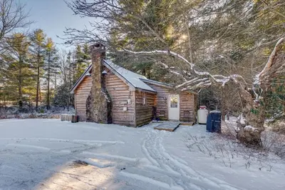 a log cabin with snow on the ground at The Cozy Cabin in Blakeslee