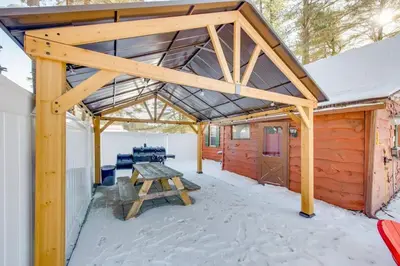a wooden pavilion with a picnic table in the snow at The Rustic Cabin in Blakeslee