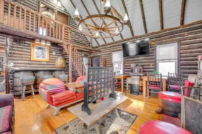 a living room with wooden walls and a fireplace at The Rustic Cabin in Blakeslee