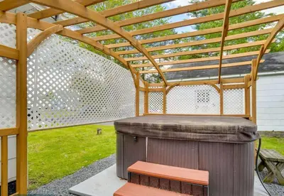 a wooden pergola with a wooden bench under it at The Babbling Brooke in Blakeslee