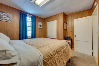 a bedroom with a large bed with blue curtains at The Babbling Brooke in Blakeslee