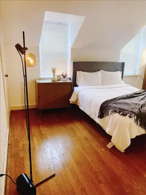 a bedroom with a bed and a floor lamp at Lin Wood Retreat in Plainfield