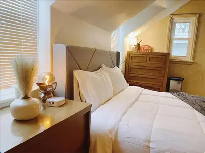 a bedroom with a bed with a clock on a table at Lin Wood Retreat in Plainfield