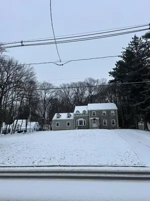 a house with snow on the ground in front of it at Lin Wood Retreat in Plainfield