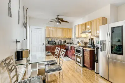 a kitchen with wooden cabinets and stainless steel appliances at 1 Mi to Downtown Newark Urban Escape! in Newark