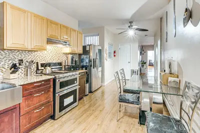 a kitchen with wooden cabinets and a glass table at 1 Mi to Downtown Newark Urban Escape! in Newark