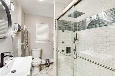 a bathroom with a shower and a toilet and a sink at 1 Mi to Downtown Newark Urban Escape! in Newark