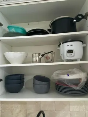 a kitchen shelf filled with pots and pans and dishes at Entire House in West Ny, NJ12 mints from NYCity Time Square in West New York