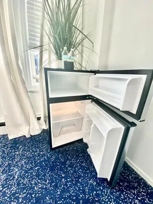 an empty refrigerator in a room with a plant at Entire House in West Ny, NJ12 mints from NYCity Time Square in West New York