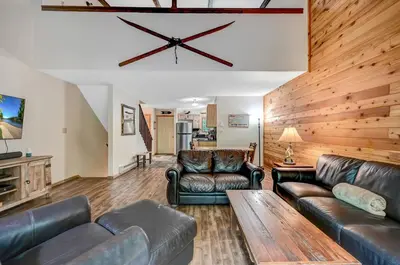 a living room with leather furniture and a wooden wall at Ski Camelback Mountain in Tannersville