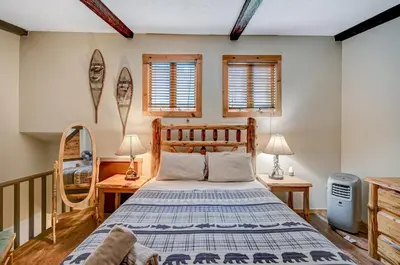 a bedroom with a bed and two tables and two windows at Ski Camelback Mountain in Tannersville
