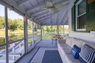 a porch with a couch and a ceiling fan at Heart's Desire, a Cottage With Stunning Lake Views in Effort