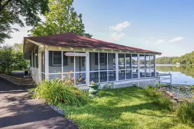 a small building with a sign on it next to a lake at Heart's Desire, a Cottage With Stunning Lake Views in Effort