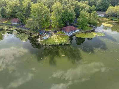 an aerial view of a house on an island in the water at Heart's Desire, a Cottage With Stunning Lake Views in Effort