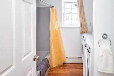 an orange shower curtain in a kitchen with a window at Spacious 3BR House, Hot Tub, Firepit, Ski Access! in Emerald Lakes