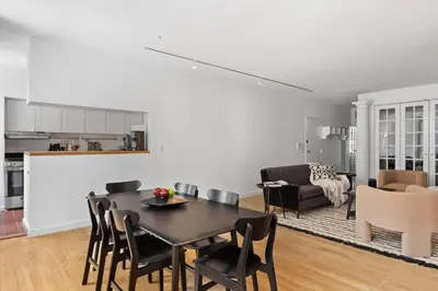 a kitchen and a living room with a table and chairs at Chelsea Canvas III by Rove Travel Charming 2BR Gem in New York