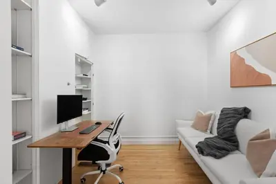 a room with a desk with a computer and a couch at Chelsea Canvas III by Rove Travel Charming 2BR Gem in New York