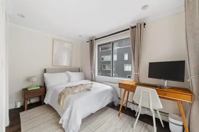 a bedroom with a bed and a desk with a television at Chelsea Vista II by Rove Travel 2BR PH with Rooftop in New York